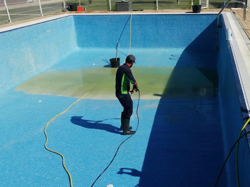 Operario de Paisajismolarioja limpiando una piscina.