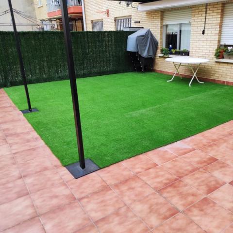Patio interior con césped artificial.